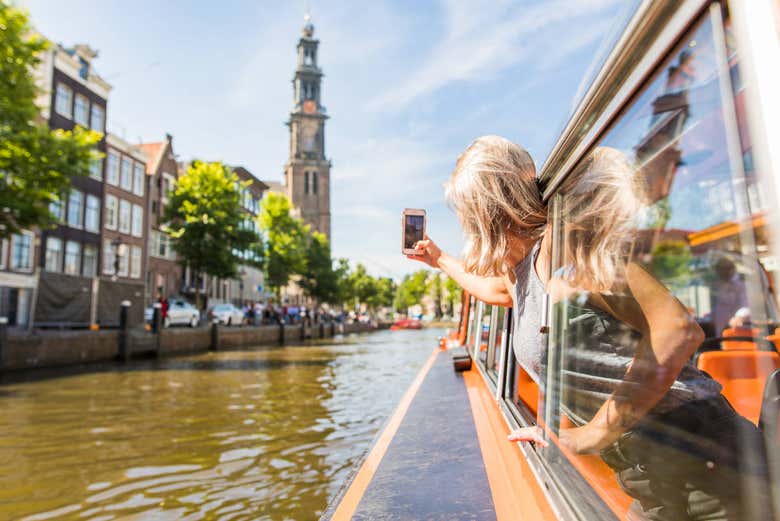 Una passeggera fotografa i canali di Amsterdam dalla barca